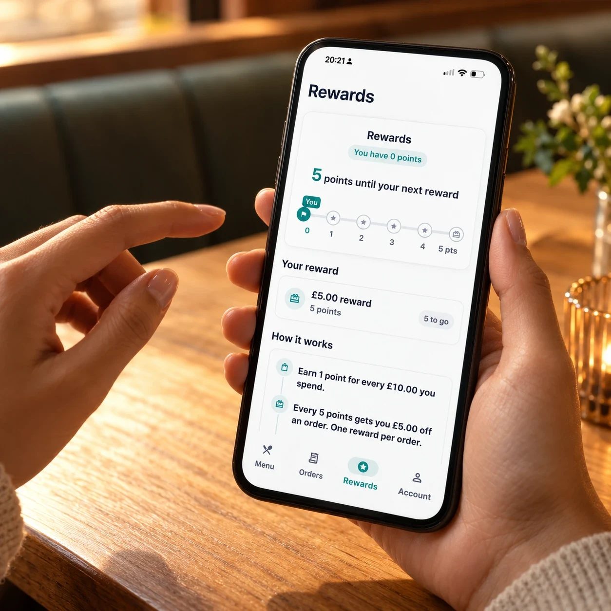 A customer holding a phone showing a takeaway app’s rewards